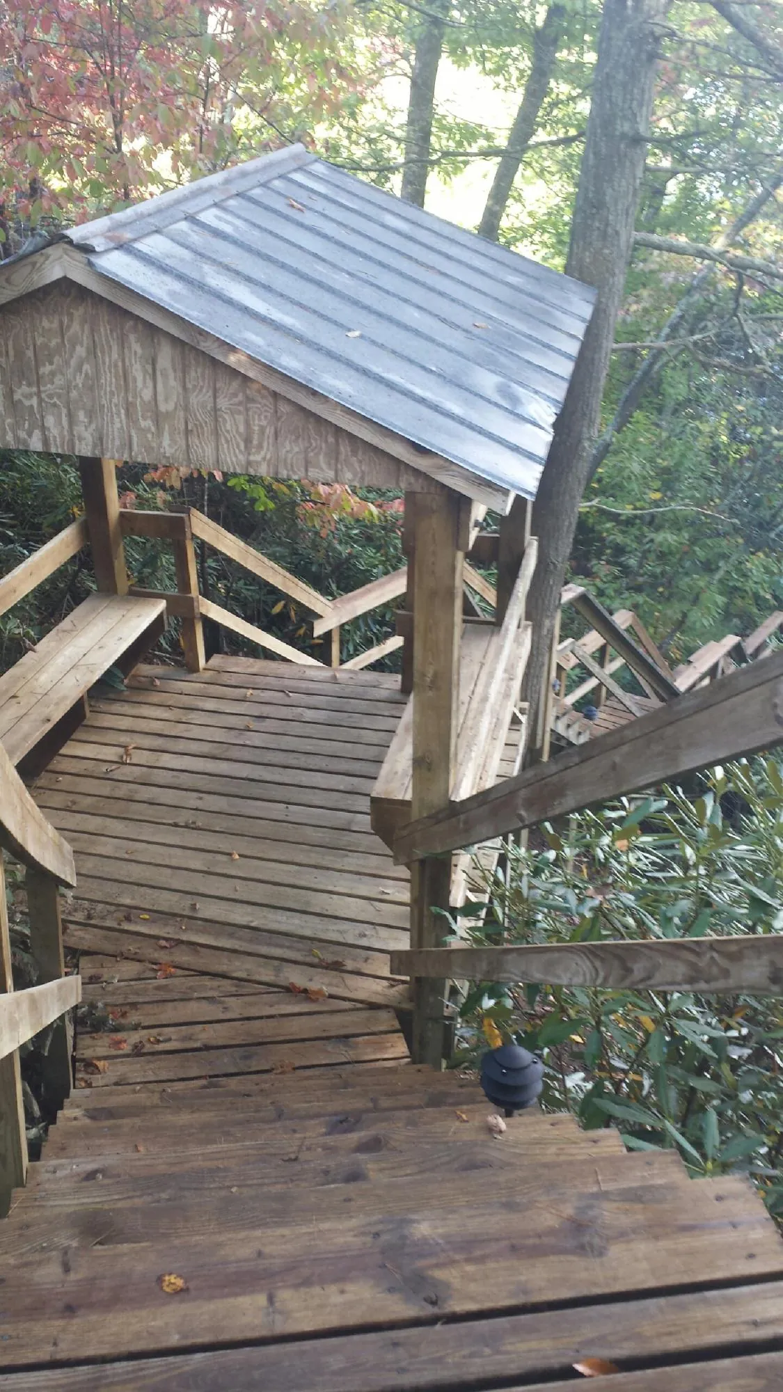 Metal roofed shelter over wooden steps on a wooded walkway — Skylight Repair & Installation work by our crew in Newbury